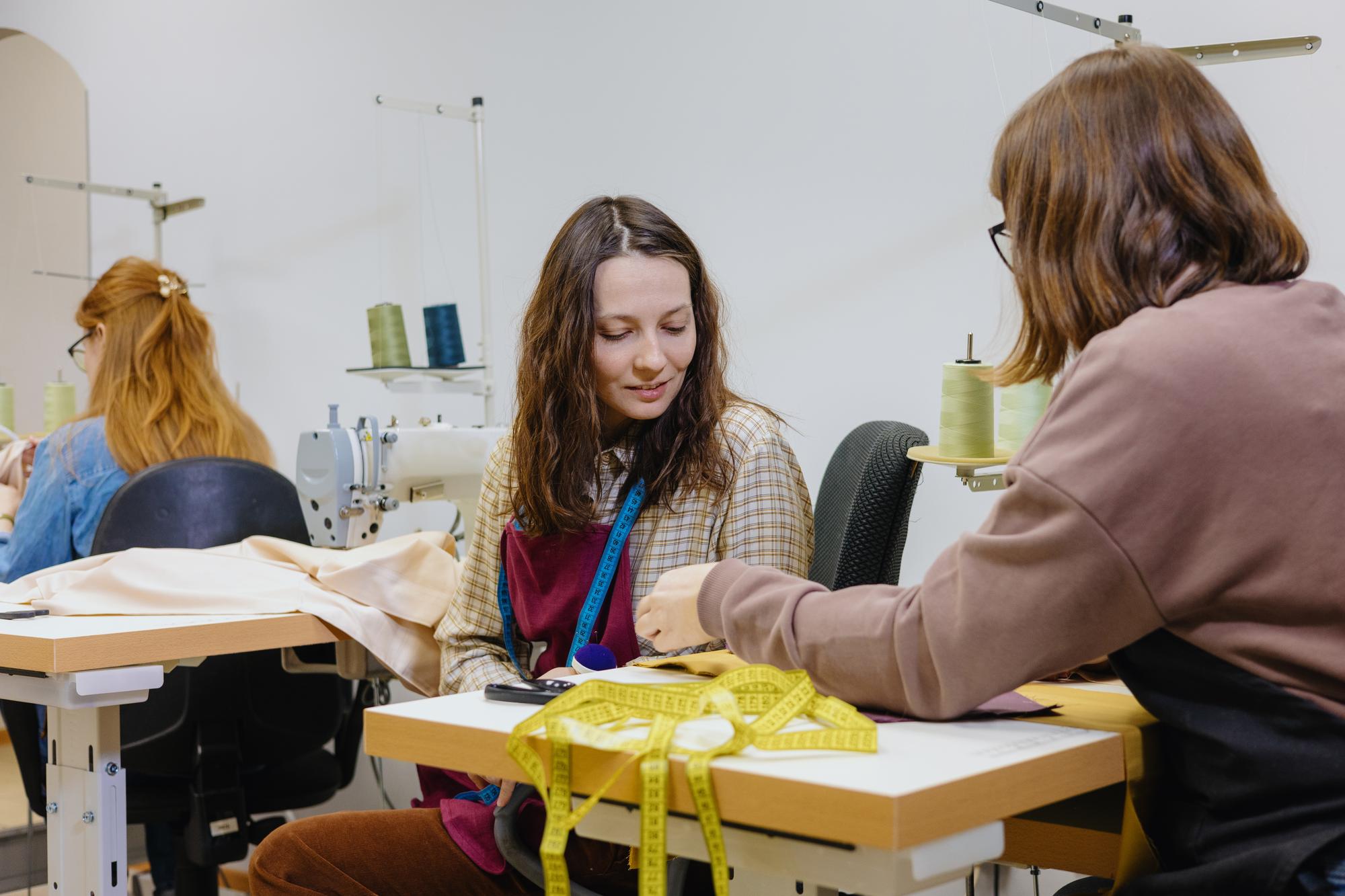 Instruktorka omawiająca wzory wyszywania we współczesnym atelier
